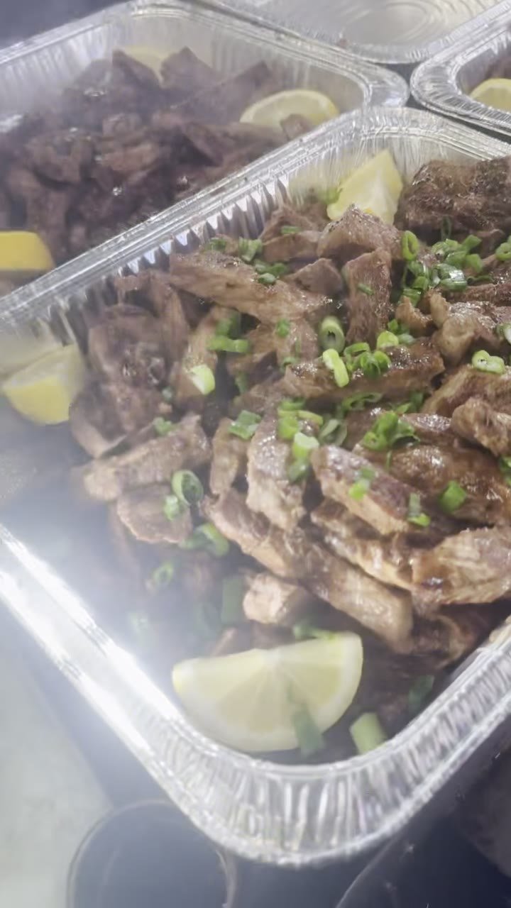 A tray of sliced hibachi steak with lemon